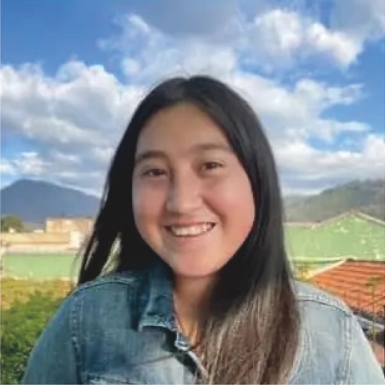 A person stands on a hill in cloudy blue sky